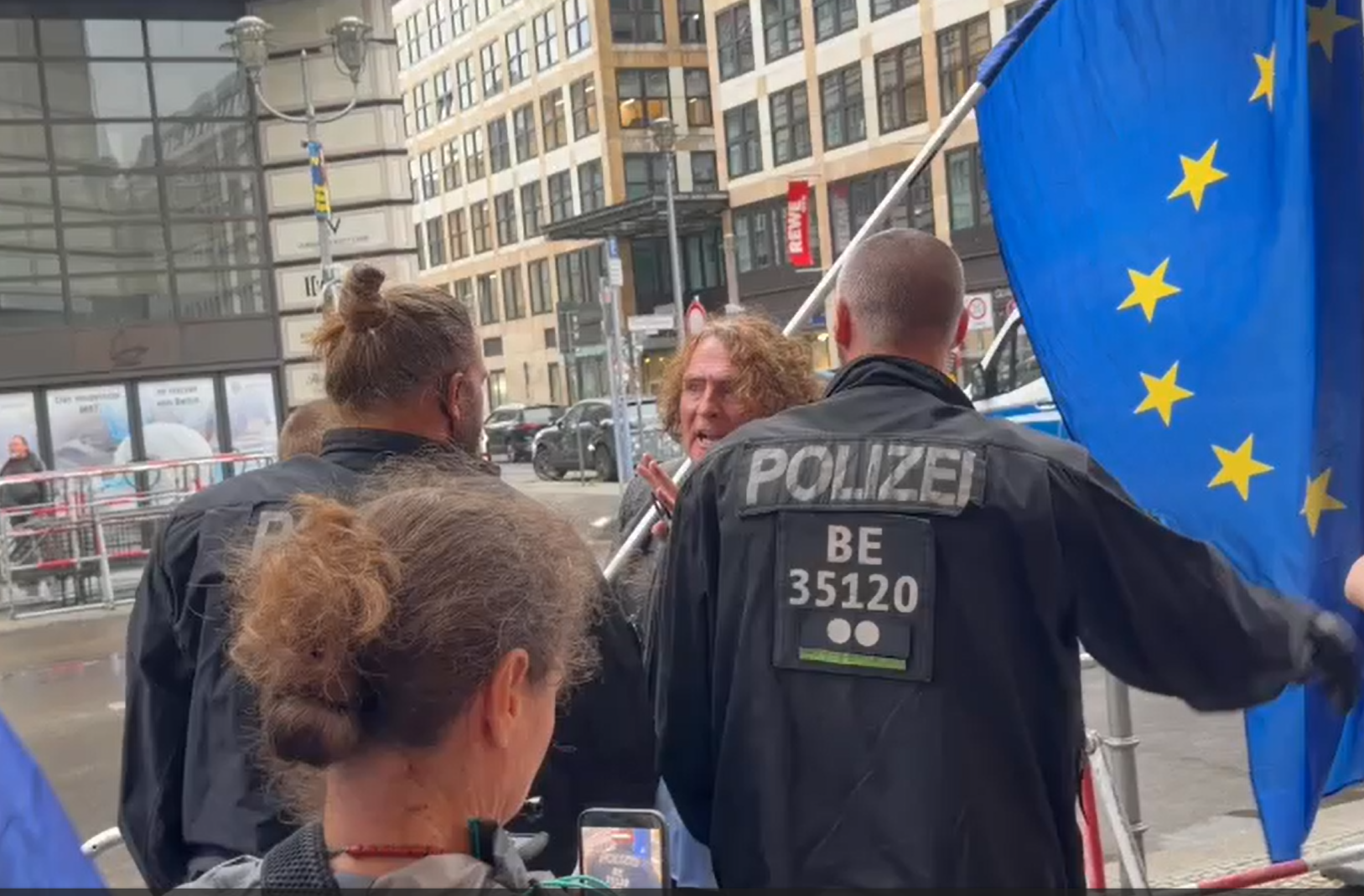 Henry Lindemeier kurz vor der Festnahme im Gespräch mit Polizeibeamten vor dem Russischen Haus.