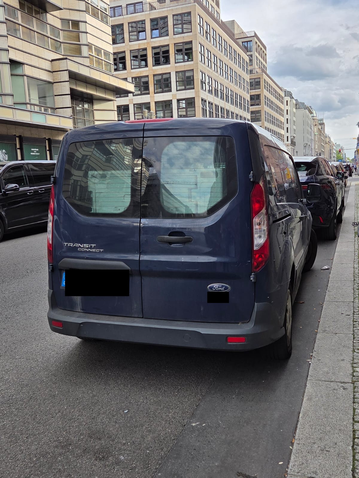 Ein dunkelblauer Kastenwagen mit Dresdner Zulassung parkt in der Friedrichstraße vor dem Russischen Haus, Kennzeichen abgedeckt.